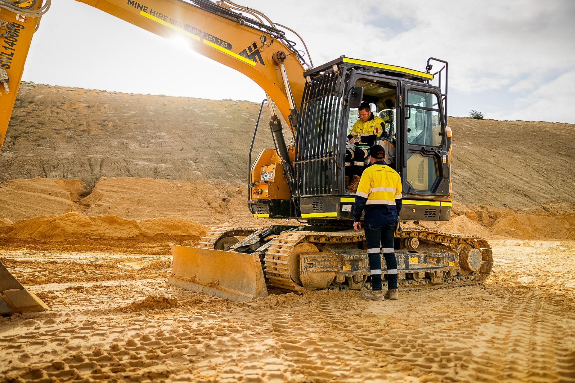 1:1 excavator training with trainer instructing student in cab